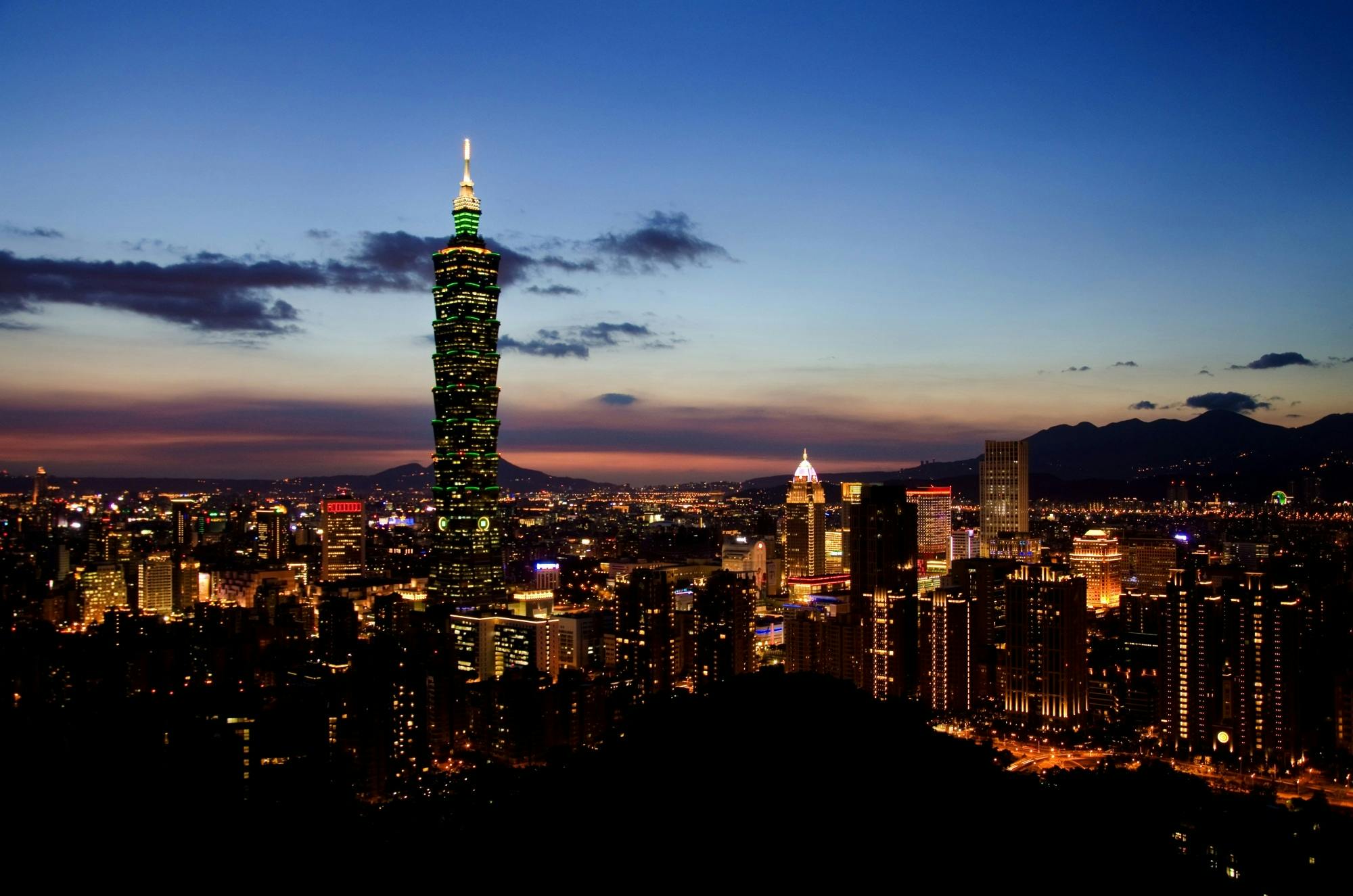Stunning view of Taipei 101 and cityscape illuminated at twilight showcasing urban charm and vibrant lights.